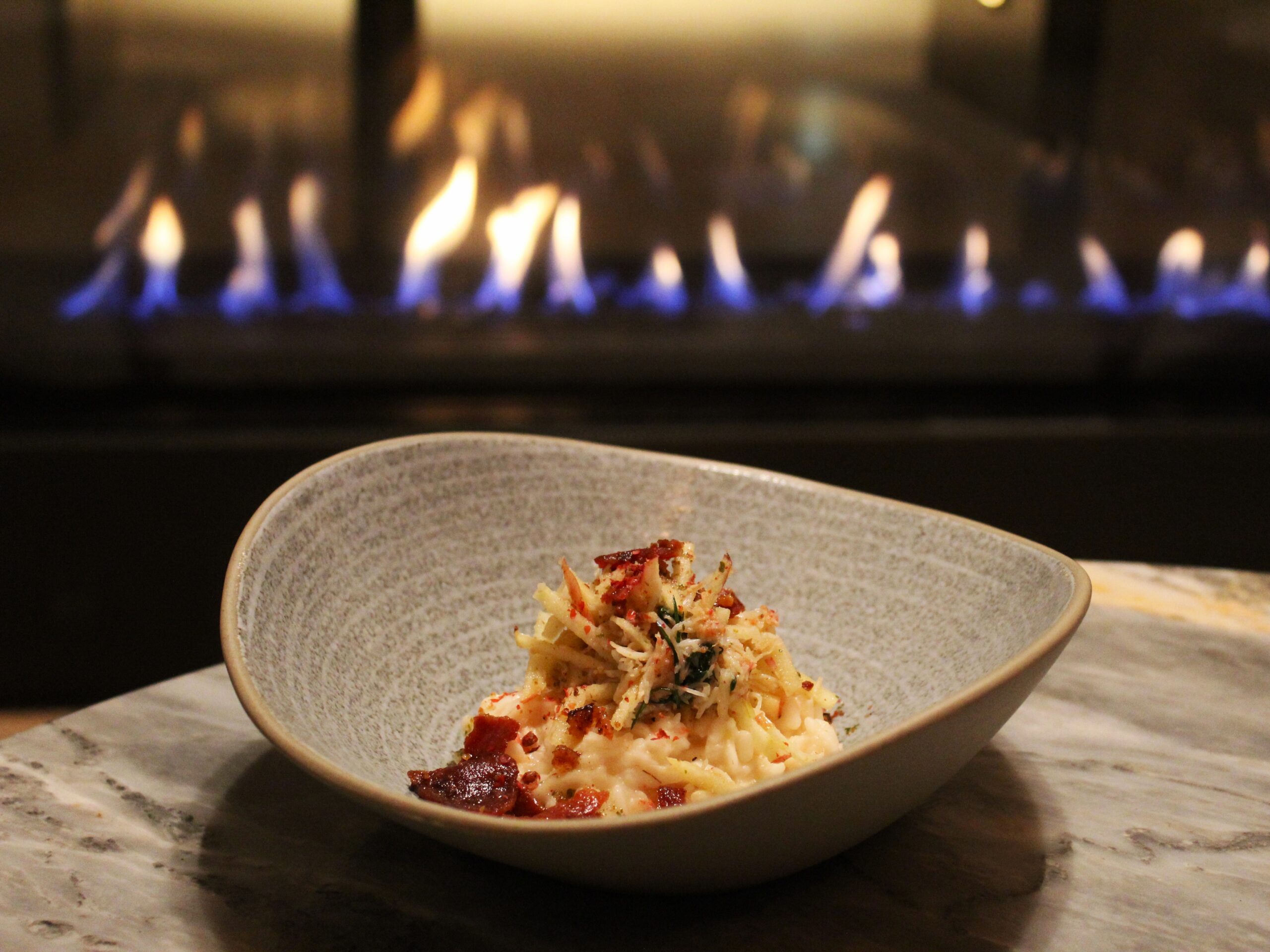 lobster risotto on a table sitting by the fire